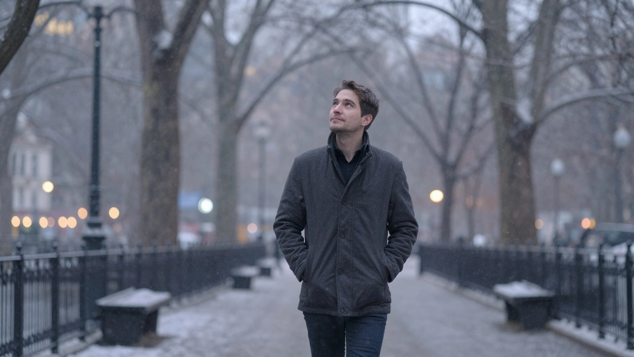 Мужчина медленно гуляет по парку при снегопаде, без телефонов, с расслабленной осанкой.