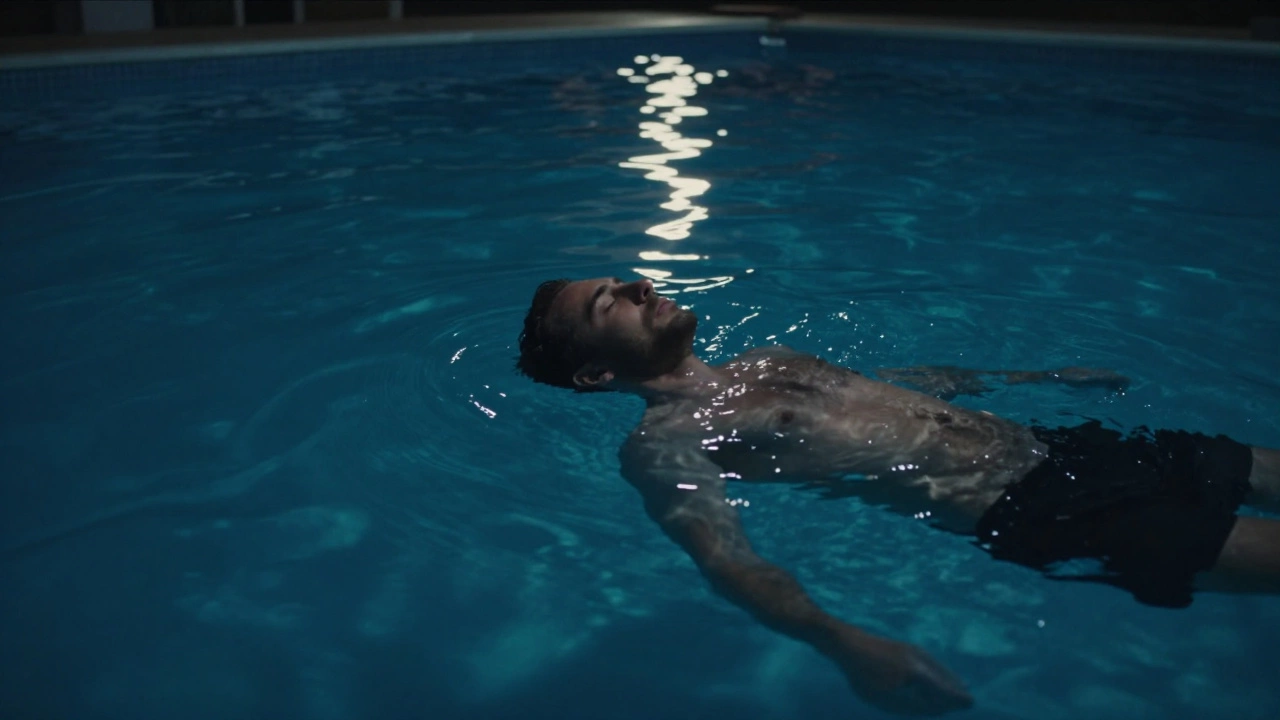 Мужчина плавает в тихом бассейне ночью, один, с закрытыми глазами, только вода и лунный свет.